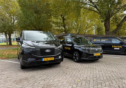 Three black vans with yellow Intertek branding. 