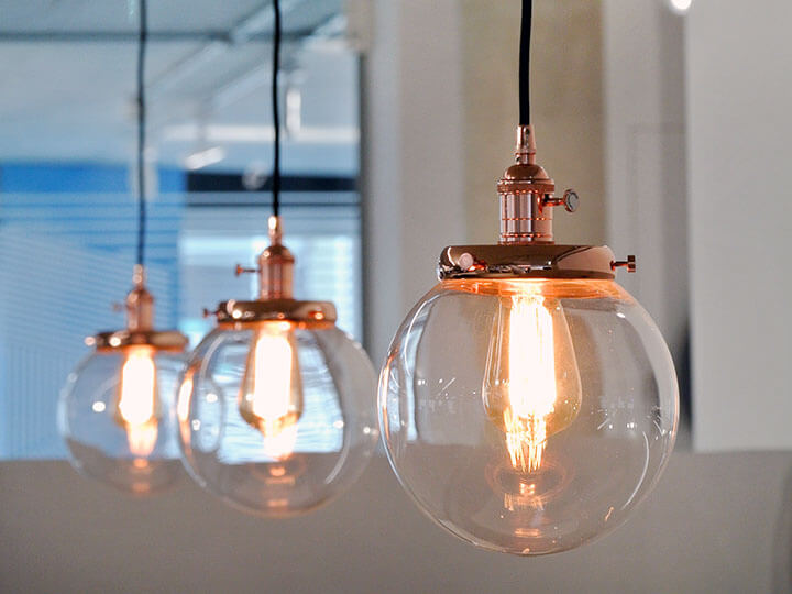 Close up of three ceiling Luminaires with spherical glass casings